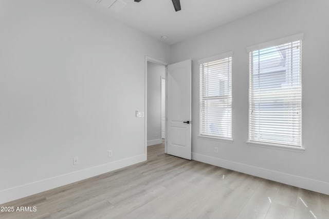 empty room featuring ceiling fan, light hardwood / wood-style flooring, and a healthy amount of sunlight