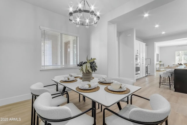 dining area featuring light hardwood / wood-style flooring and an inviting chandelier