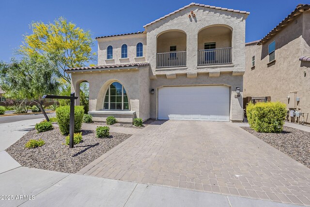 3310 E Los Gatos Dr, Phoenix, AZ 85050 - mediterranean / spanish-style home featuring a balcony, stucco siding, a garage, a tile roof, and decorative driveway