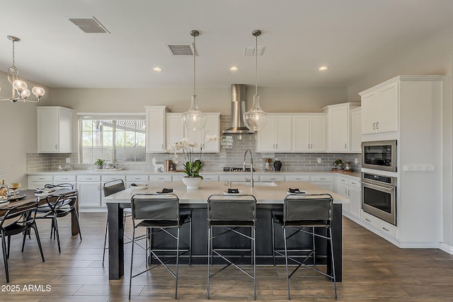 3310 E Los Gatos Dr, Phoenix, AZ 85050 - kitchen with stainless steel oven, wall chimney range hood, a sink, a kitchen breakfast bar, and recessed lighting