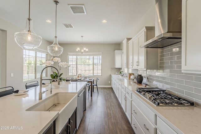 3310 E Los Gatos Dr, Phoenix, AZ 85050 - kitchen featuring wall chimney exhaust hood, stainless steel gas cooktop, a sink, dark wood-style floors, and tasteful backsplash