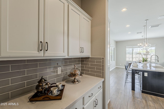 3310 E Los Gatos Dr, Phoenix, AZ 85050 - kitchen with backsplash, a sink, white cabinetry, baseboards, and recessed lighting
