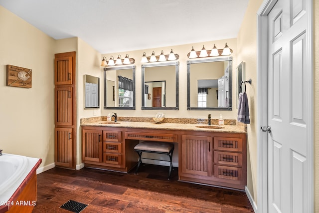 bathroom featuring a tub to relax in, vanity, and hardwood / wood-style flooring