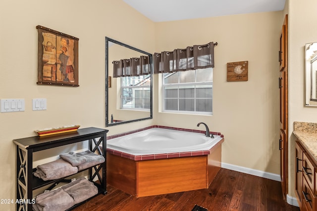 bathroom featuring a bath, hardwood / wood-style flooring, and vanity