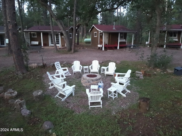 back of house with an outbuilding and an outdoor fire pit