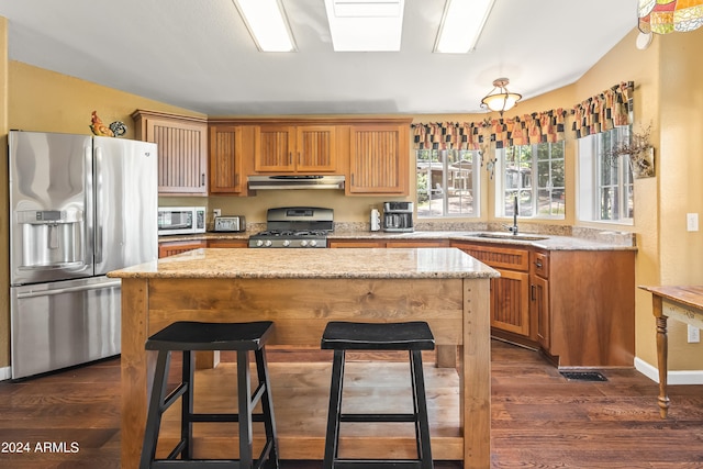 kitchen featuring a center island, stainless steel appliances, sink, and dark wood-type flooring