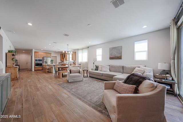 10964 W Garfield St, Avondale, AZ 85323 - living room with plenty of natural light, light wood finished floors, recessed lighting, and a chandelier