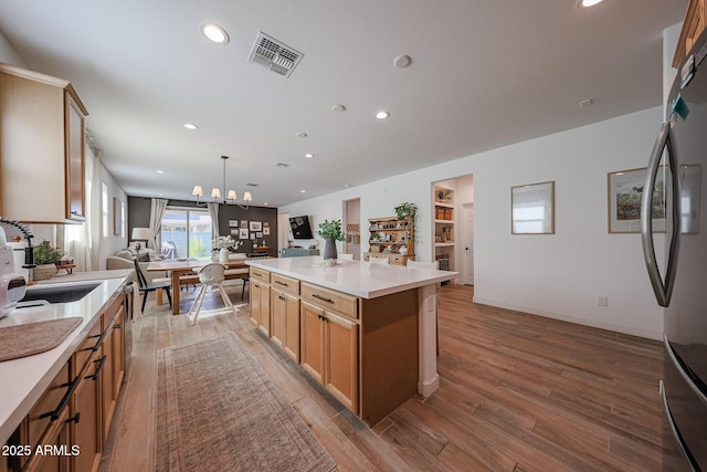 10964 W Garfield St, Avondale, AZ 85323 - kitchen featuring open floor plan, recessed lighting, light wood finished floors, freestanding refrigerator, and light countertops