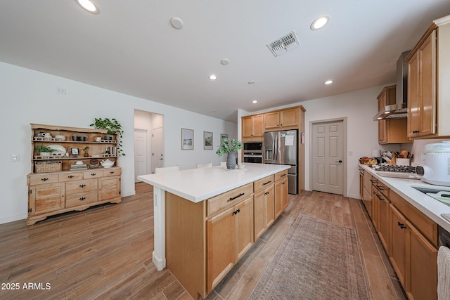 10964 W Garfield St, Avondale, AZ 85323 - kitchen with stainless steel appliances, a center island, recessed lighting, wall chimney range hood, and light wood finished floors