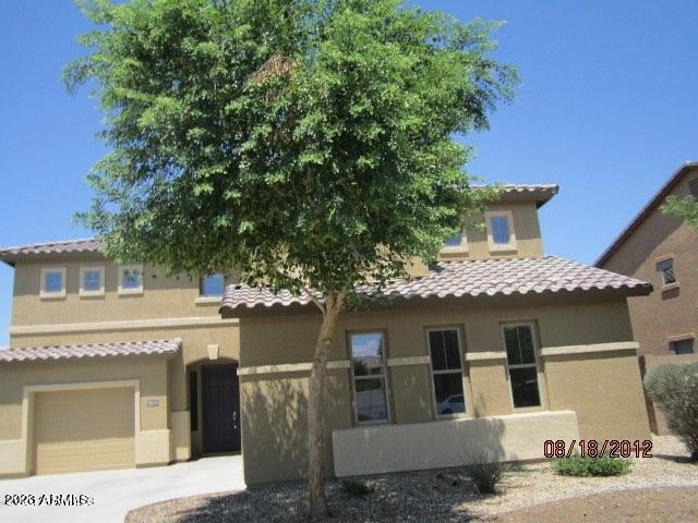 9018 W Superior Ave, Tolleson, AZ 85353 - mediterranean / spanish home featuring stucco siding, a tile roof, a garage, and concrete driveway