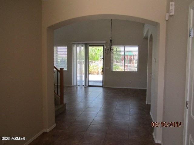 9018 W Superior Ave, Tolleson, AZ 85353 - unfurnished dining area featuring arched walkways, a chandelier, and stairway