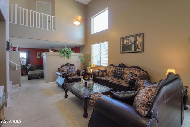 carpeted living room featuring a towering ceiling