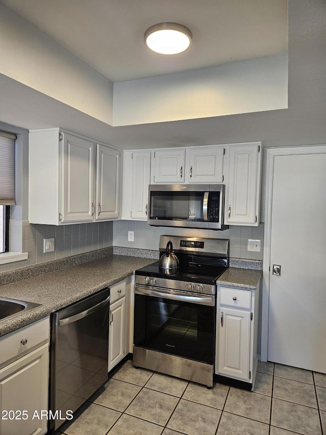 kitchen featuring white cabinets, light tile patterned floors, and stainless steel appliances