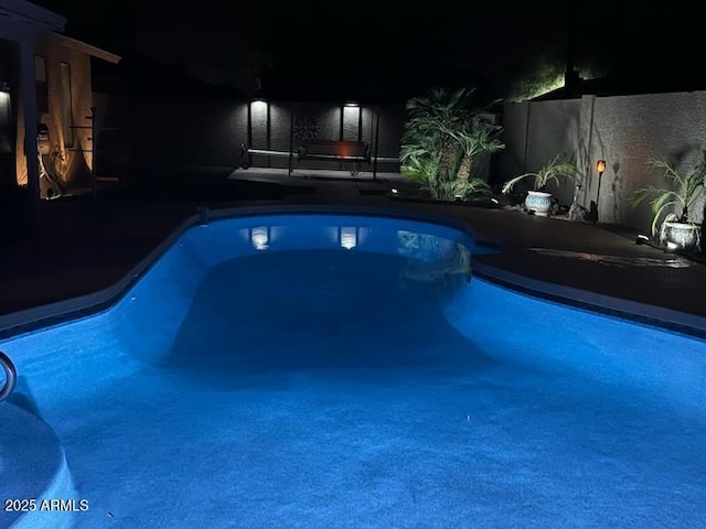 view of pool at twilight