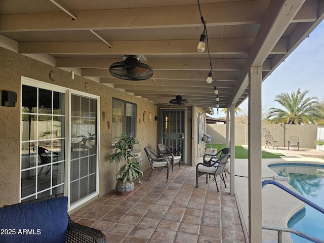 view of patio featuring ceiling fan and a fenced in pool