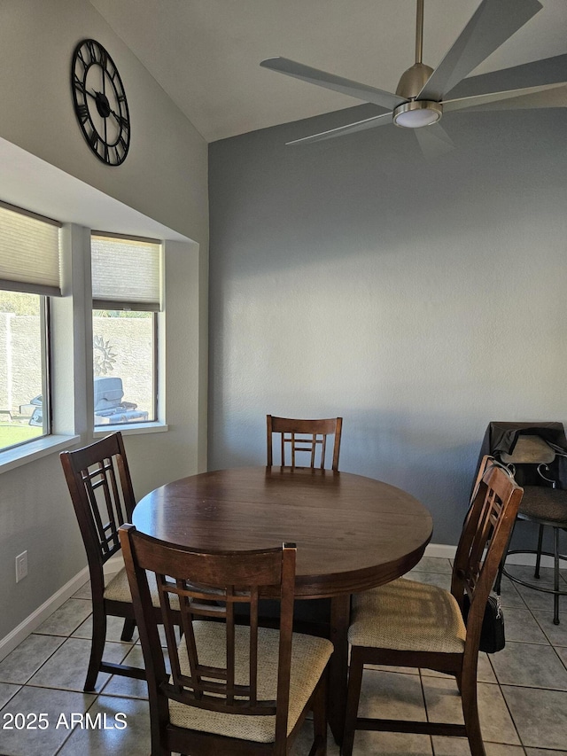 tiled dining area featuring ceiling fan and vaulted ceiling