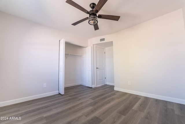 unfurnished bedroom with ceiling fan, a closet, and dark wood-type flooring