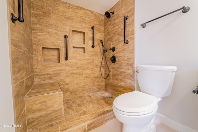 bathroom with tiled shower, toilet, and tile patterned floors