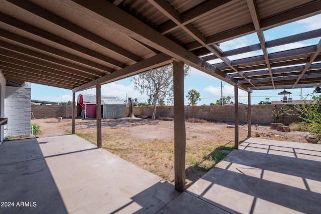 view of patio featuring a storage unit