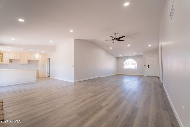 unfurnished living room with light wood-type flooring, vaulted ceiling, and ceiling fan