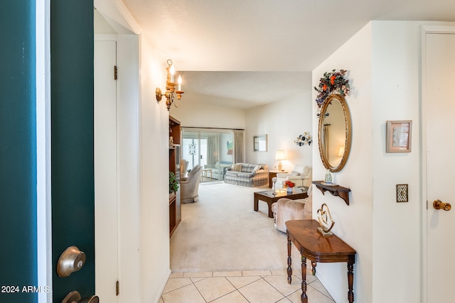 hall with light carpet and a textured ceiling