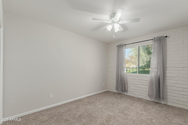 empty room featuring ceiling fan, brick wall, and carpet