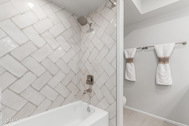 bathroom featuring tile patterned flooring, tiled shower / bath, and toilet