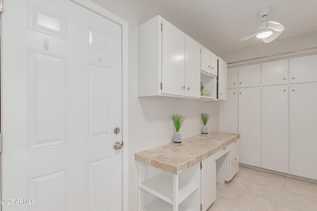 kitchen with light tile patterned flooring, tile counters, and white cabinets