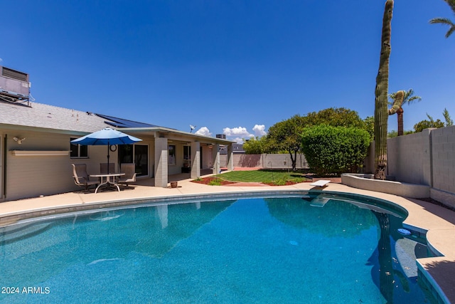 view of pool with a diving board and a patio area