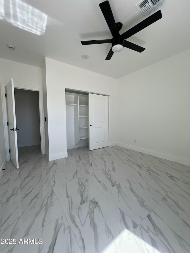 3755 N 363rd Ave, Tonopah, AZ 85354 - unfurnished bedroom with baseboards, a closet, marble look tile flooring, and a ceiling fan