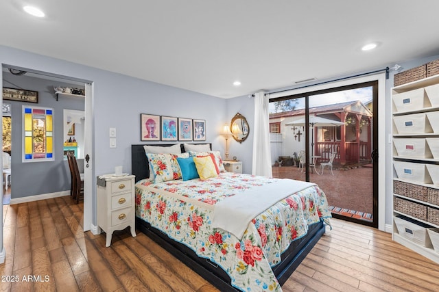 bedroom featuring wood-type flooring and access to outside