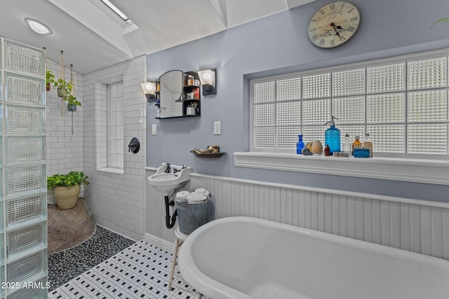 bathroom with tile patterned flooring and lofted ceiling with skylight