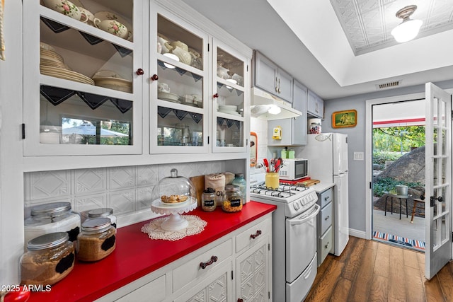 kitchen featuring white cabinets, plenty of natural light, white appliances, and tasteful backsplash