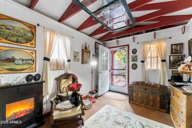 interior space featuring a fireplace, lofted ceiling with beams, and a wealth of natural light