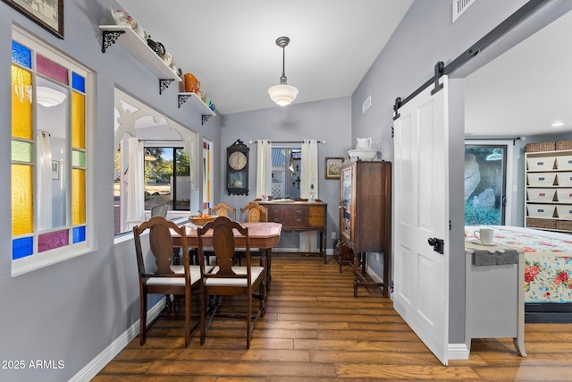 dining room featuring dark hardwood / wood-style floors and a barn door