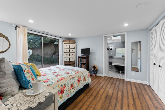 bedroom featuring ensuite bath, access to exterior, multiple windows, dark hardwood / wood-style flooring, and a closet