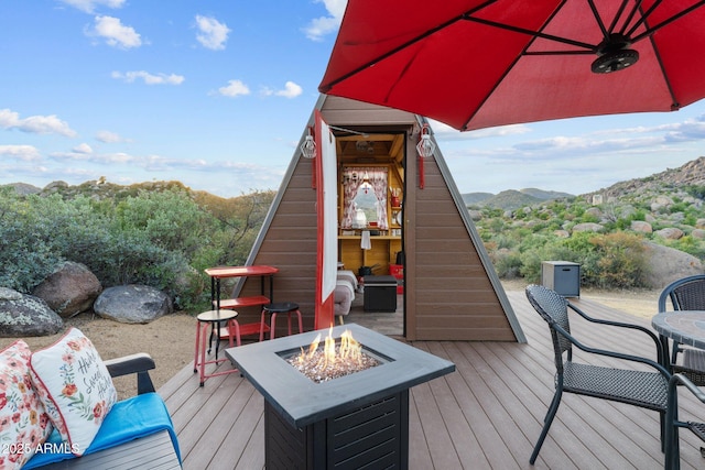 deck featuring a mountain view and a fire pit