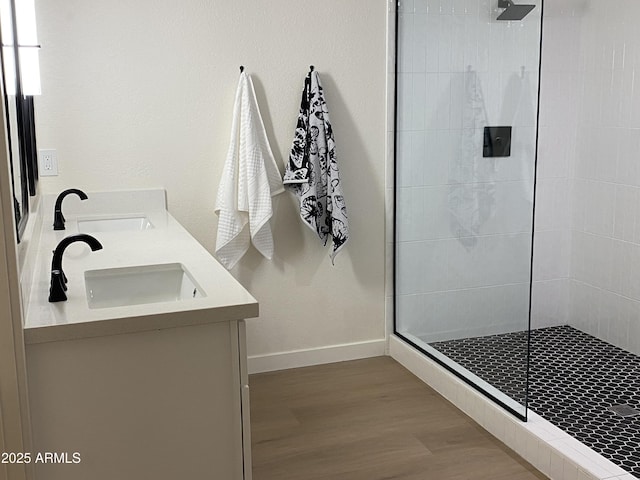 bathroom with tiled shower, vanity, and hardwood / wood-style flooring