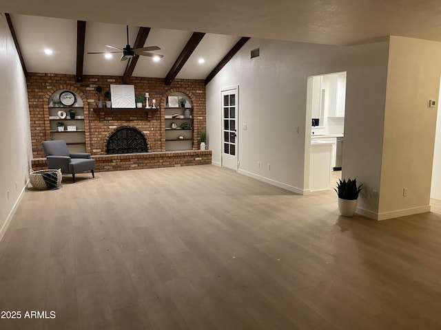 unfurnished living room featuring vaulted ceiling with beams, ceiling fan, hardwood / wood-style floors, and a brick fireplace