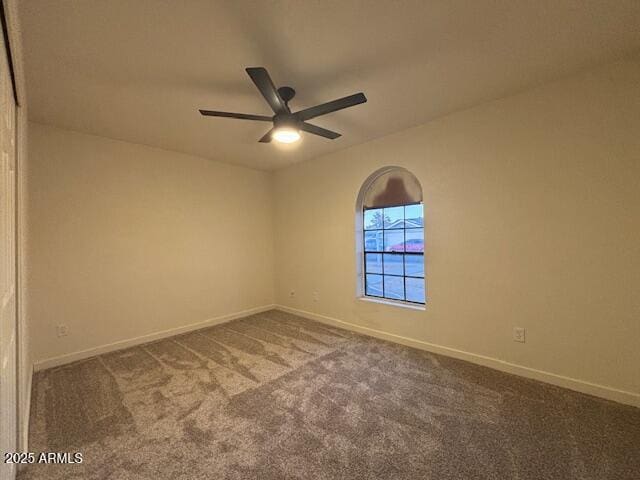 carpeted spare room with ceiling fan