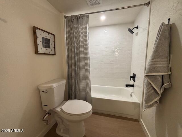 bathroom featuring hardwood / wood-style flooring, toilet, and shower / tub combo