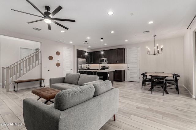 living room featuring ceiling fan with notable chandelier