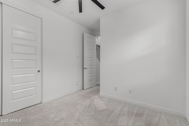 unfurnished bedroom featuring ceiling fan, light colored carpet, and a closet