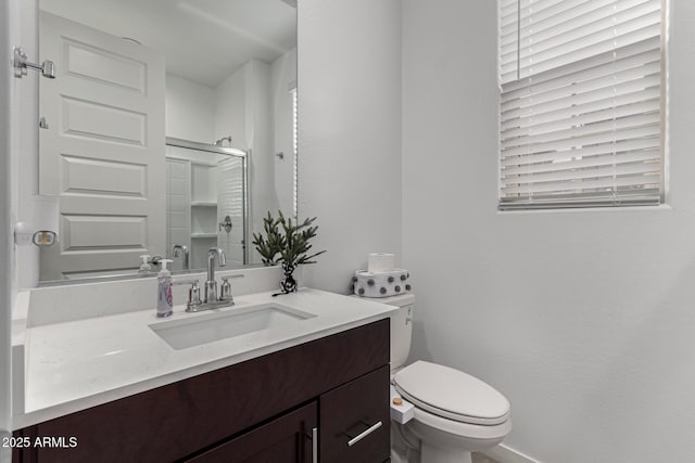 bathroom featuring vanity, toilet, and a shower with shower door