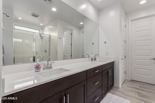 bathroom featuring wood-type flooring, vanity, and an enclosed shower