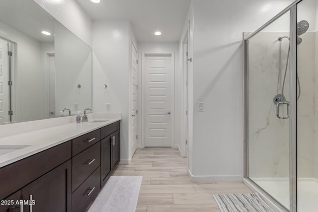 bathroom with hardwood / wood-style floors, vanity, and walk in shower