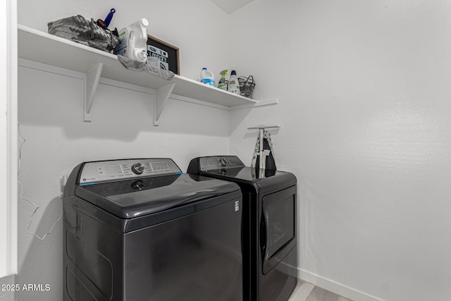 clothes washing area featuring washing machine and clothes dryer and hardwood / wood-style floors