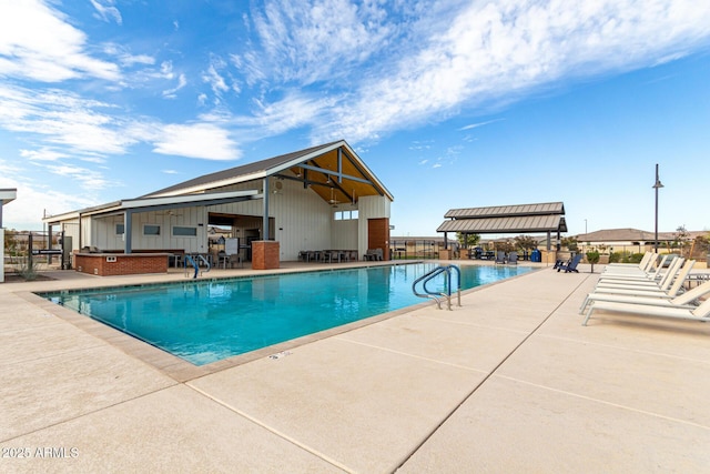 view of pool featuring area for grilling and a patio