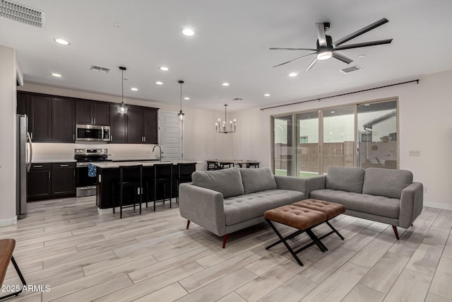 living room with ceiling fan with notable chandelier