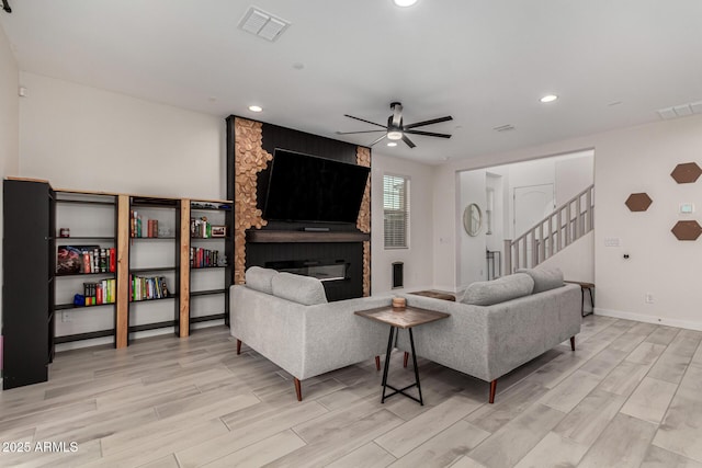 living room featuring a fireplace and ceiling fan